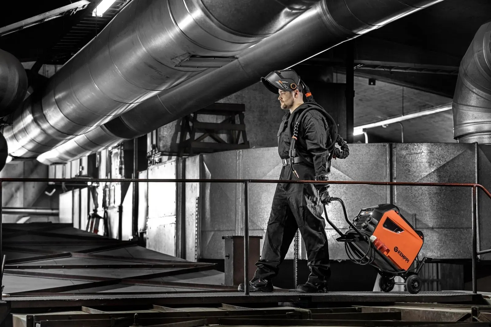 A welder pulling a Master M on its trolley along a gantry