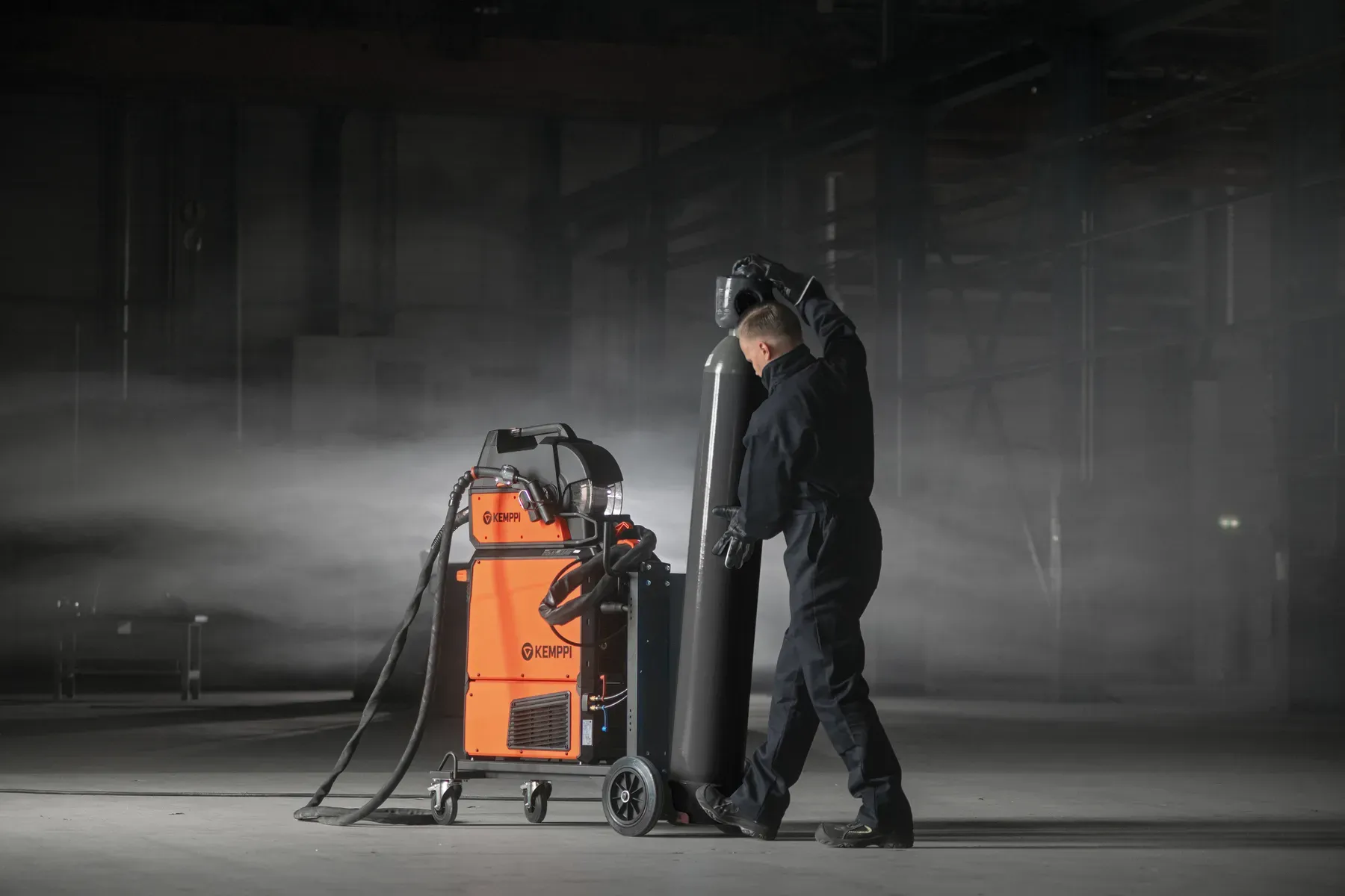 A welder loading a gas cylinder onto the X5 trolley