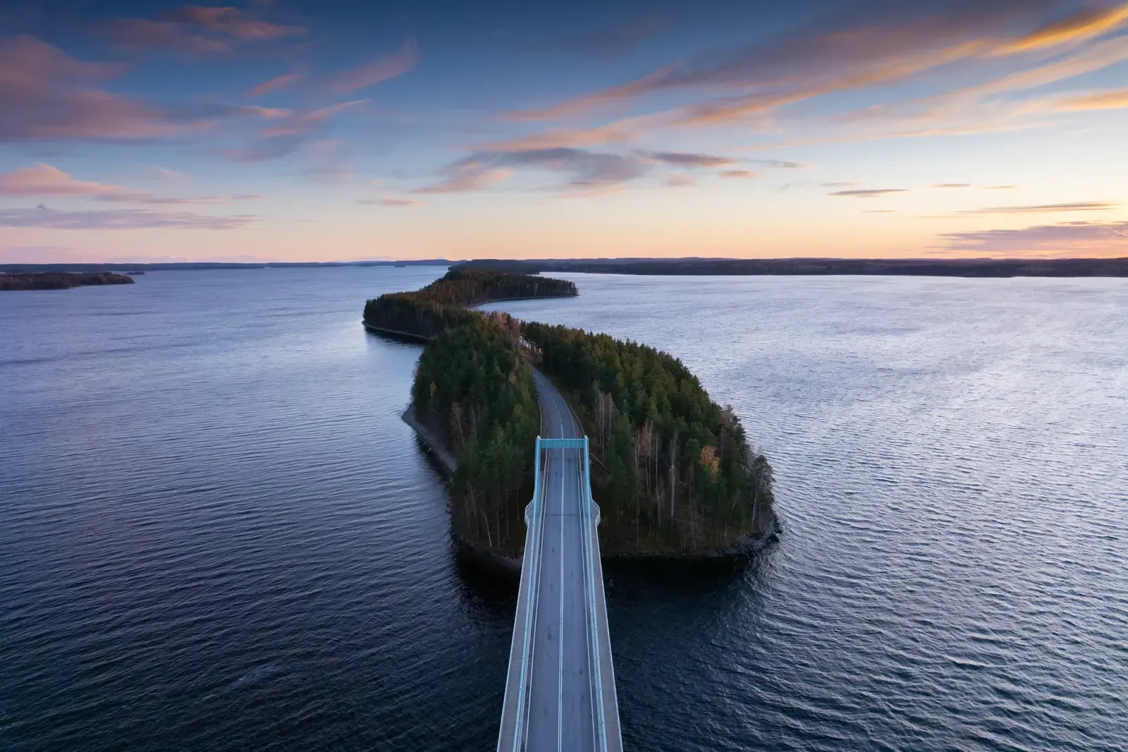 The same bridge and island under a coloured evening sky