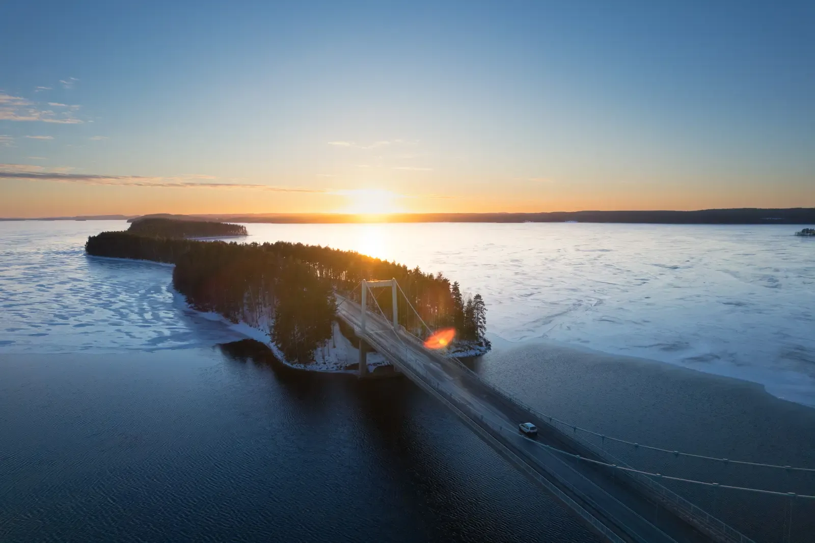 Sunrise over a bridge and a wooded island